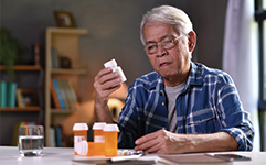 older man going through his pill bottles