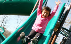 Young girl sliding down slide