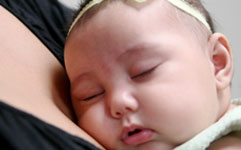 Baby girl snuggled with mother
