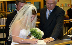 couple signing wedding license with officiant