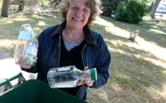 woman putting recycling into recycling container