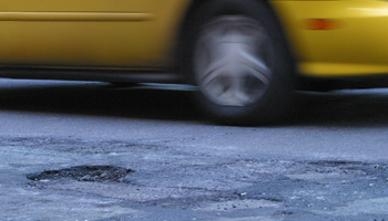 taxi driving by pothole