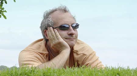 A man laying on the grass and enjoying a view.