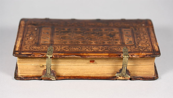 close up of an old book with clips for binding