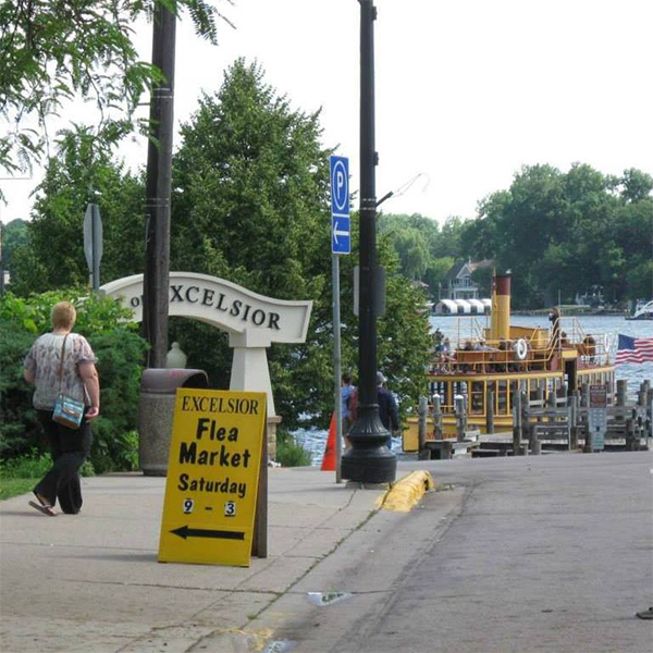 excelsior flea market sign on sidewalk
