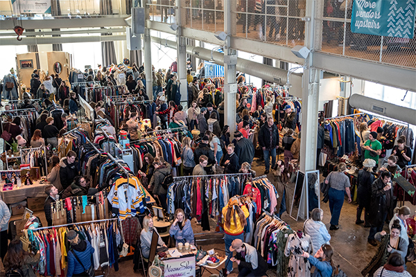 overhead shot of marketplace with people looking at clothing hung up on racks