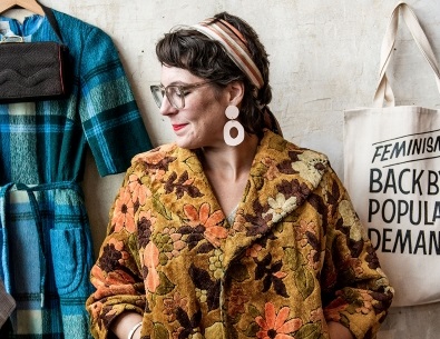 Woman trying on vintage jacket, looking left