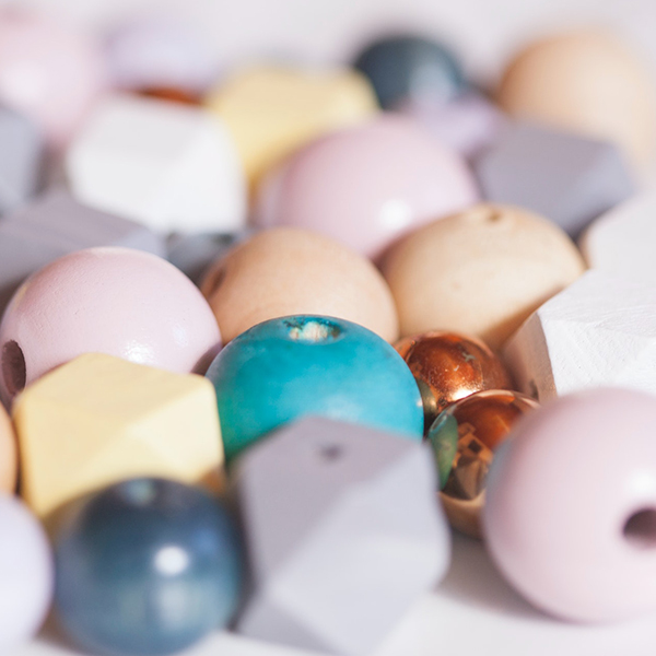 close up image of a variety of wooden beads in different colors and shapes
