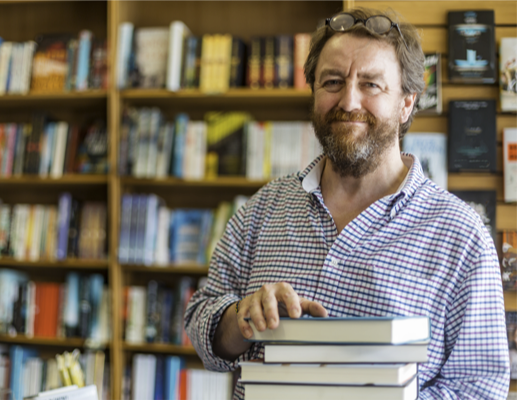 man holding stack of books