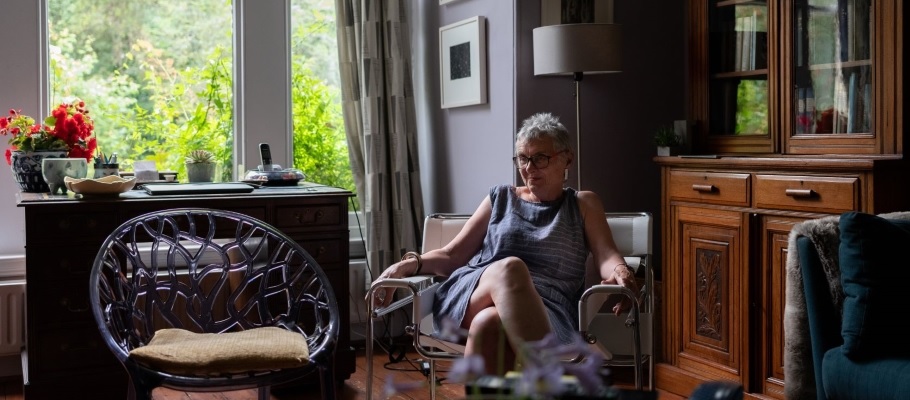 Woman in her home with open window surrounded by reclaimed items