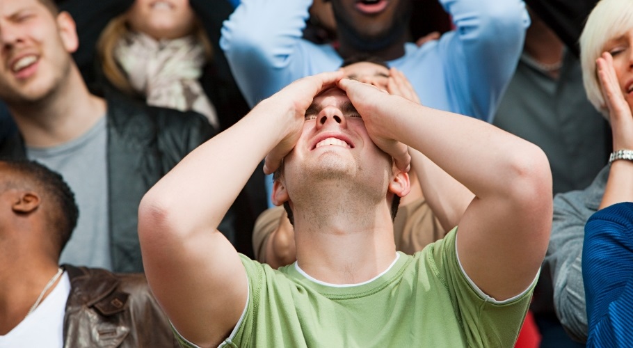 Sports fan holds head in hands, disappointed
