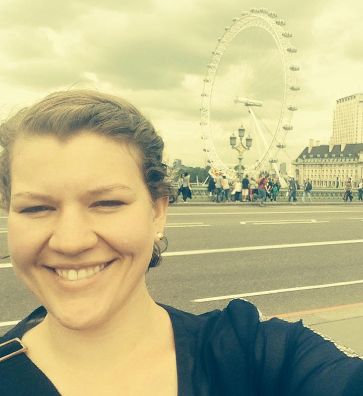 woman outside standing in front of a ferris wheel