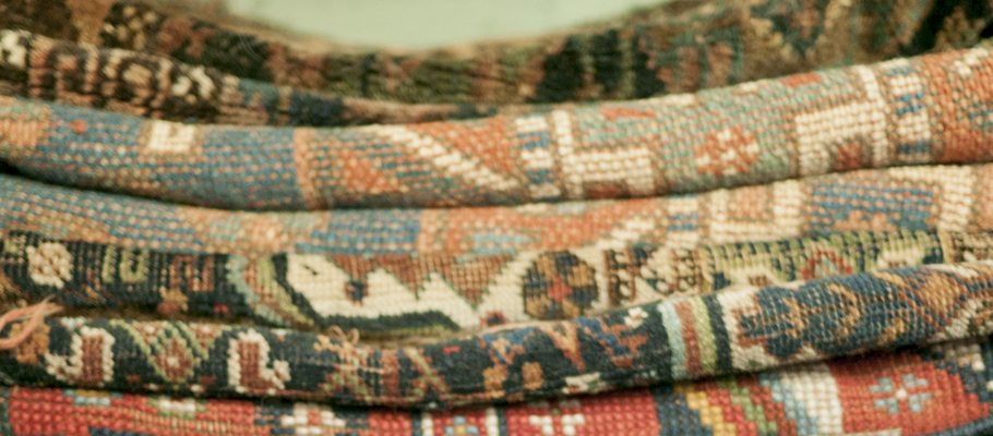 stack of carpets and tapestries