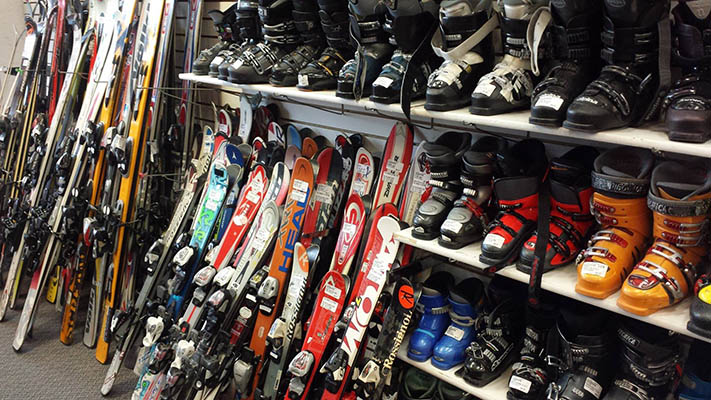 Used skis and ski boots on shelves