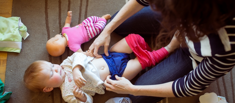 Overhead view of woman changing baby's cloth diaper