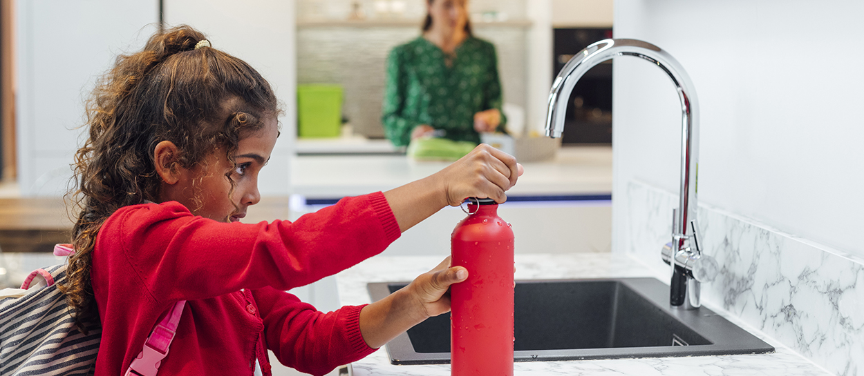Girl refilling reusable water bottle
