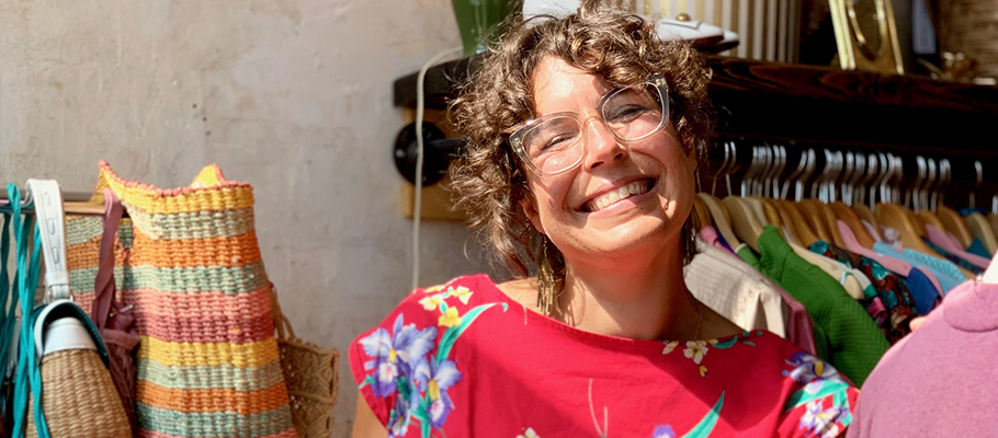 Amanda smiling in front of clothes racks