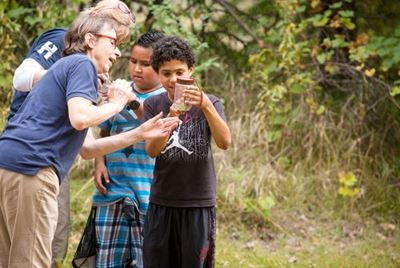 Youth and educators viewing jars of insects at NatureFest