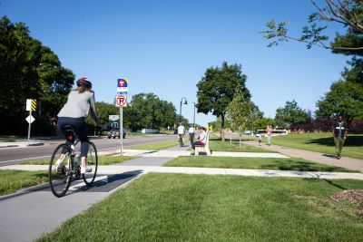 People on bikeway next to walkers on path alongside roadway