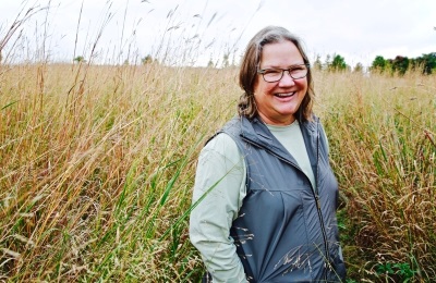 Woman standing in field of tall prairie grass