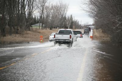 Cars driving through flooded county road
