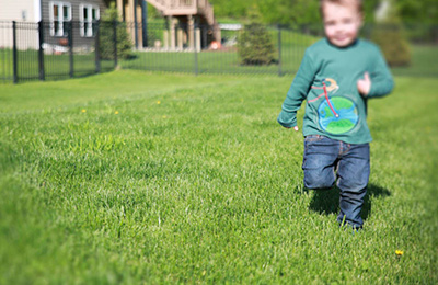 Boy running on lawn wearing shirt with bike and earth as wheel