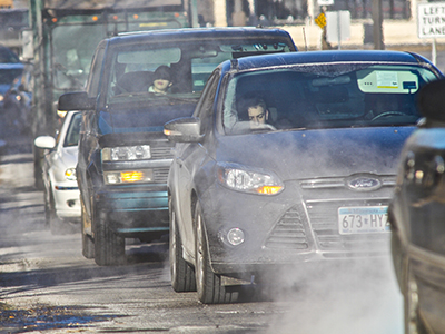 Cars sitting in traffic with exhaust coming from tailpipes