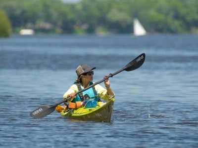 Woman in green kayak on a lake.