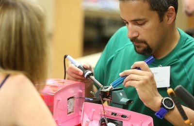 Man fixing pink sewing machine