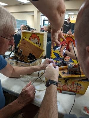 Two men fixing vintage toy