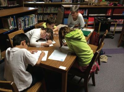 Kids at table writing letter to editor