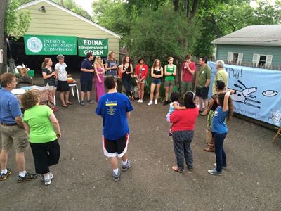 Neighbors in driveways standing in circle talking about climate solutions
