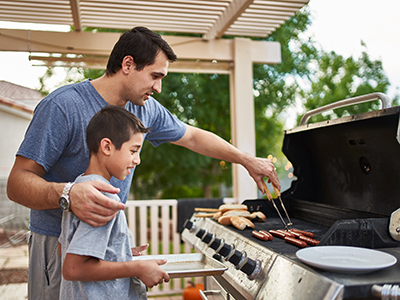 Father and son grilling outside