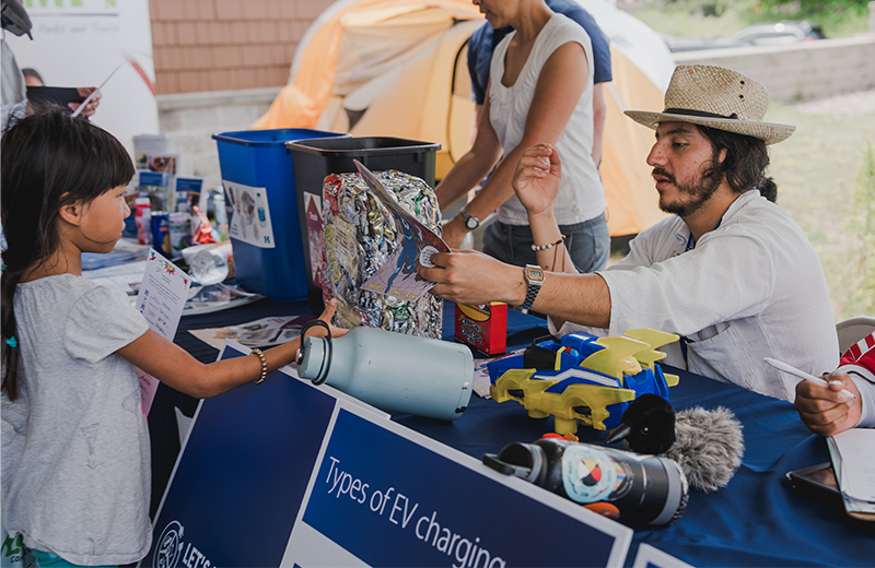man at event table helping a young customer