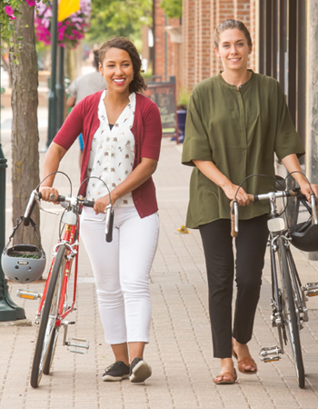 Two women biking in downtown Robbinsdale
