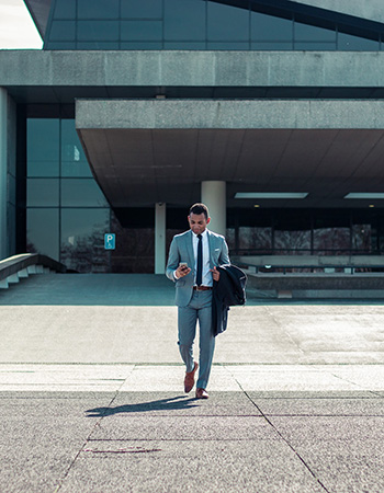 A man in a business suit checking his phone. 