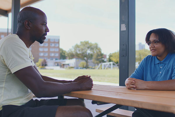 social worker speaking to a teen outside