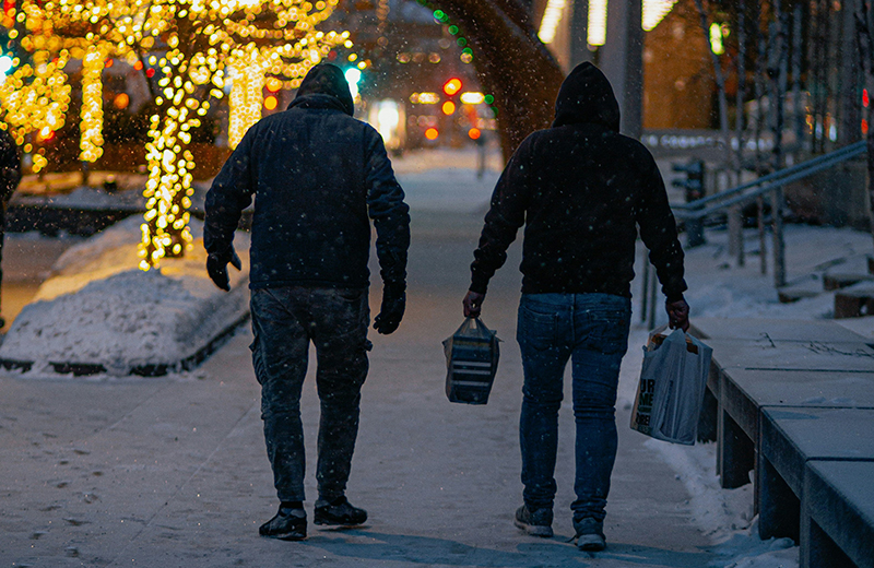men walking outside in the snow on the sidewalk