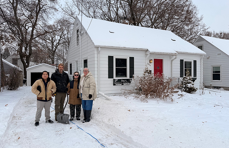 people standing outside a house in winter