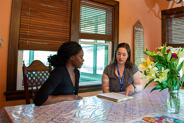 two women sitting at a table inside